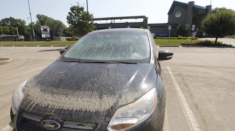 A car still sits in the parking lot of Carlton Davidson Stadium Wednesday, covered with mud and full of water from the flooding last week. Bill Lackey/Staff