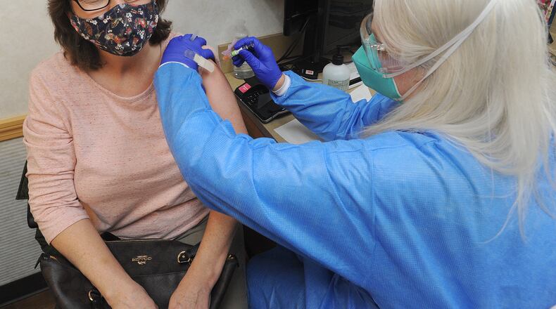 Denisea Mount, a Nurse Practitioner, at the MinuteClinic inside the CVS on Far Hills Ave. gives a flu shot Friday to patient Tracy Young. MARSHALL GORBY\STAFF