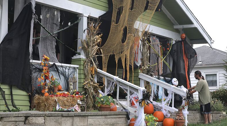 Mo Nagle puts the finishing touches on the Halloween decorations on his house along East Cecil Street in Springfield Monday. According to Nagle, his family decorates every year for Halloween. BILL LACKEY/STAFF