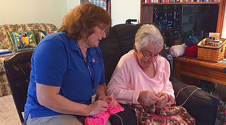 Comfort Keepers employee Beth Bowling (left) helps Kitty Parrett with help around her home. Comfort Keepers is celebrating 20 years in business. JEFF GUERINI/STAFF