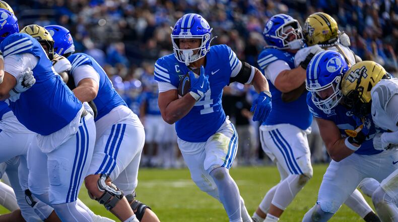 BYU running back LJ Martin (4) runs the ball in for a touchdown during the first half an NCAA college football game, Saturday, Nov. 29, 2025, in Provo, Utah. (AP Photo/Tyler Tate)