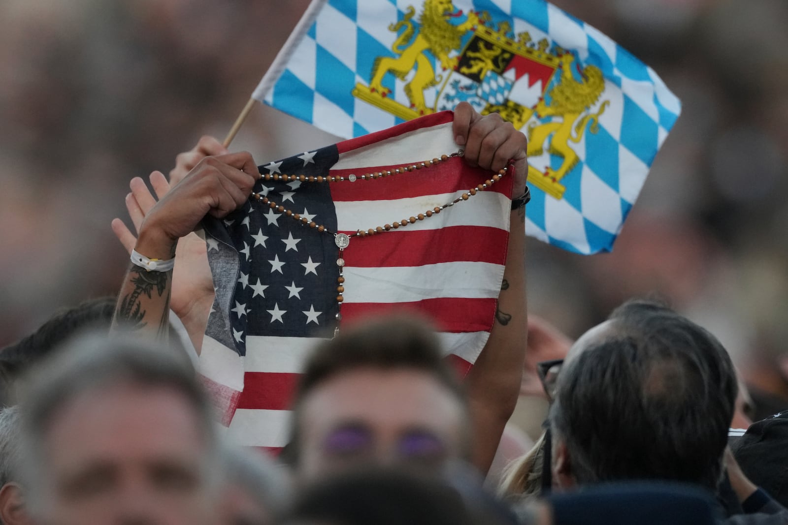 Faithful hold an American flag and a rosary following the election of Pope Leo XIV at the Vatican, Thursday, May 8, 2025. (AP Photo/Andrew Medichini)