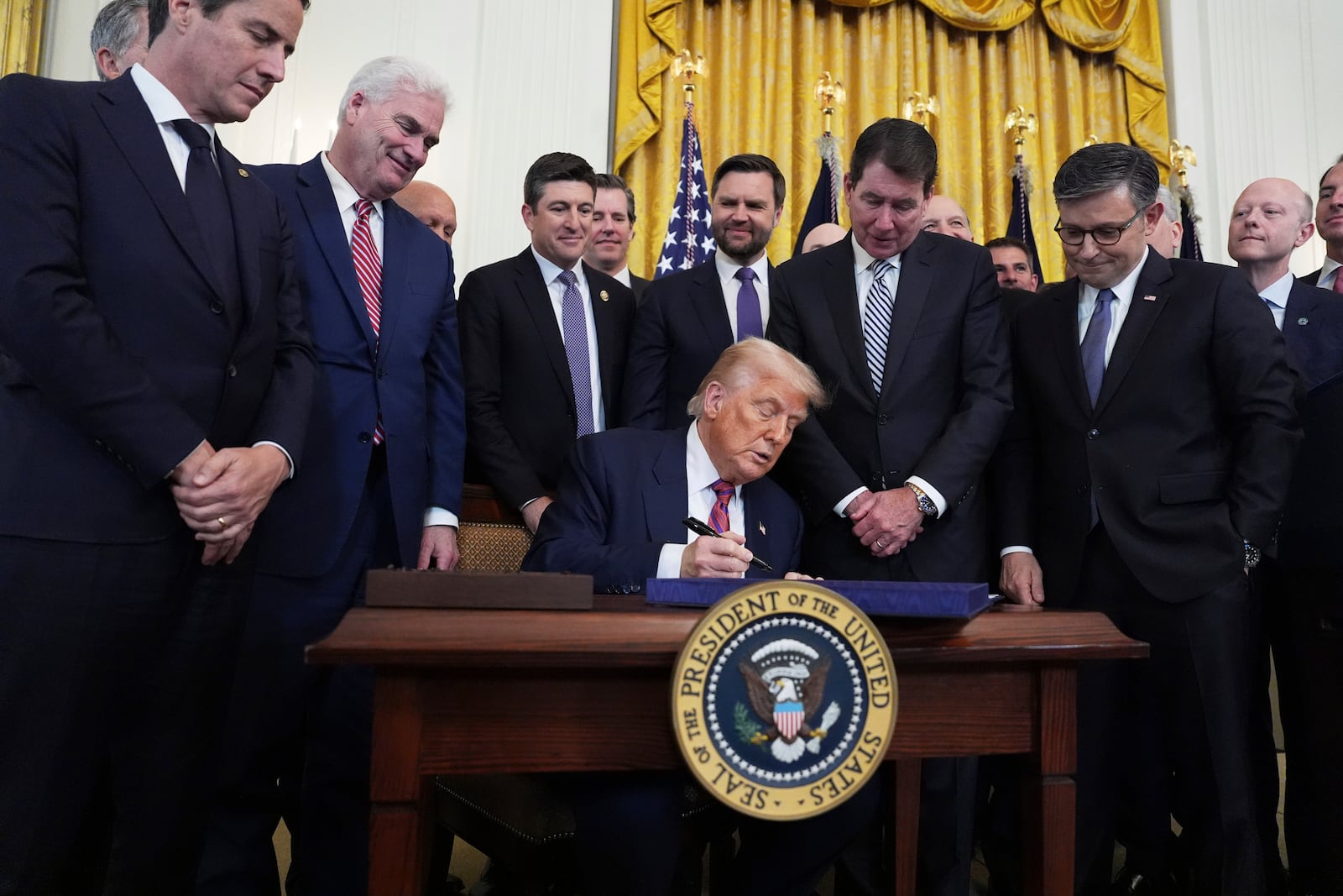 President Donald Trump signs the GENIUS Act, a bill that regulates stablecoins, a type of cryptocurrency, in the East Room of the White House, Friday, July 18, 2025, in Washington. (AP Photo/Evan Vucci)