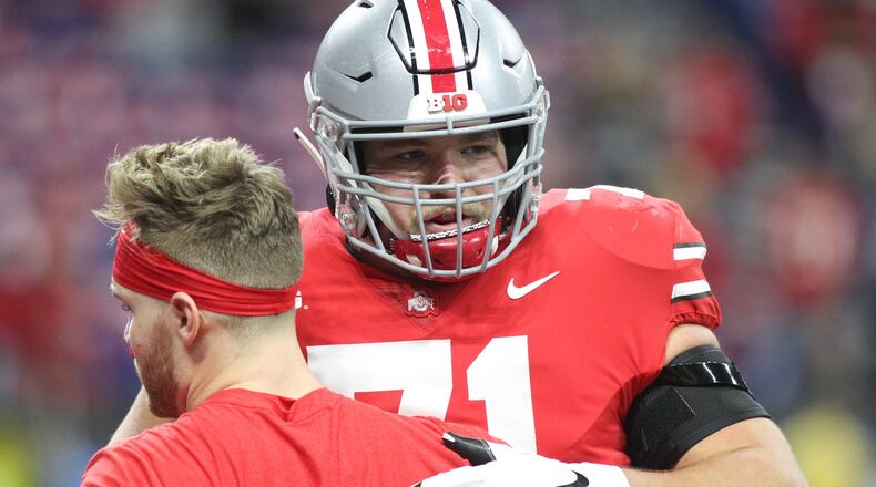 Ohio State's Josh Myers hugs Tate Martell during pregame warmups before the Big Ten Championship on Dec. 1, 2018, at Lucas Oil Stadium in Indianapolis.