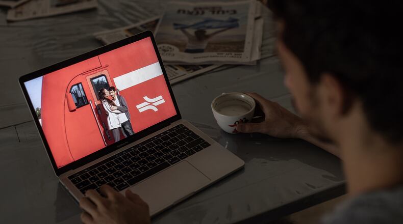 Noam Alon, whose girlfriend Inbar Haiman was taken hostage at the Tribe of Nova gathering, a trance music festival, with a photo of her on his laptop, at his parents’ house in Binyamina, Israel, Oct. 13, 2023. The savage attack slaughtered at least 260 partygoers, some of whom were also taken hostage, at a trance music festival held during the Jewish holiday of Sukkot. (Avishag Shaar-Yashuv/The New York Times).