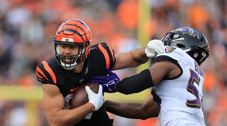 Cincinnati Bengals' C.J. Uzomah, left, is tackled by Baltimore Ravens' Tyus Bowser (54) during the second half of an NFL football game, Sunday, Dec. 26, 2021, in Cincinnati. (AP Photo/Aaron Doster)