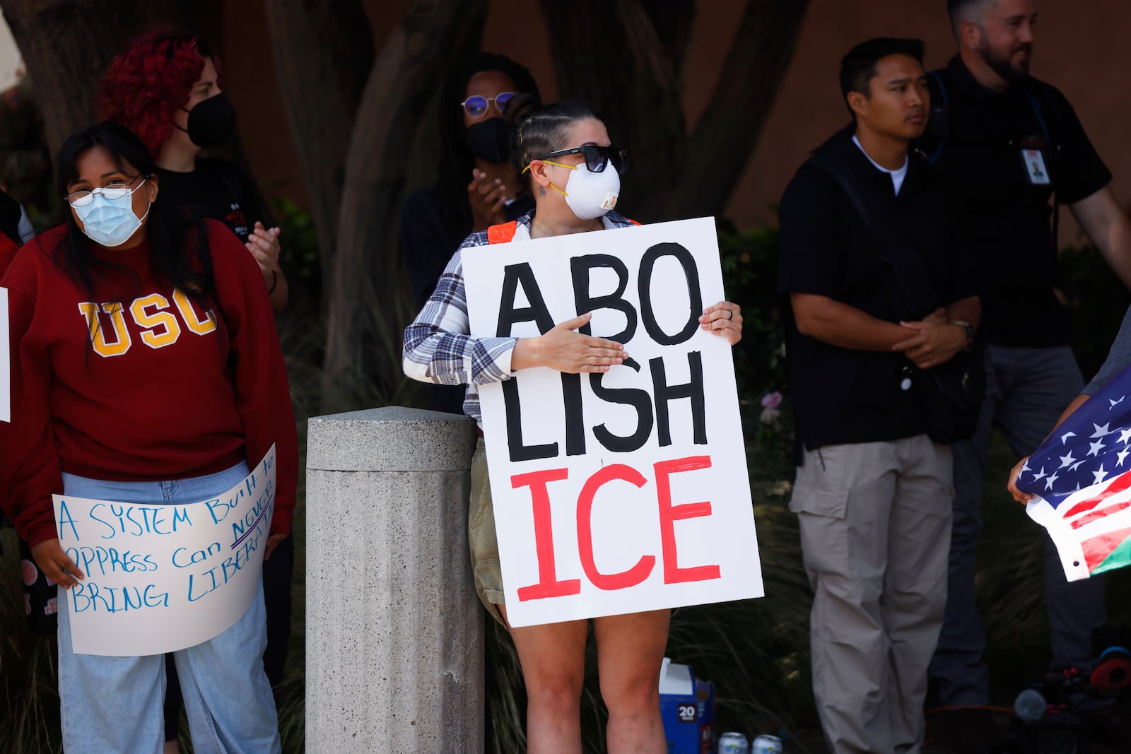 Demonstrators hold signs as they protest, Thursday, June 12, 2025, in Los Angeles. (AP Photo/Etienne Laurent)