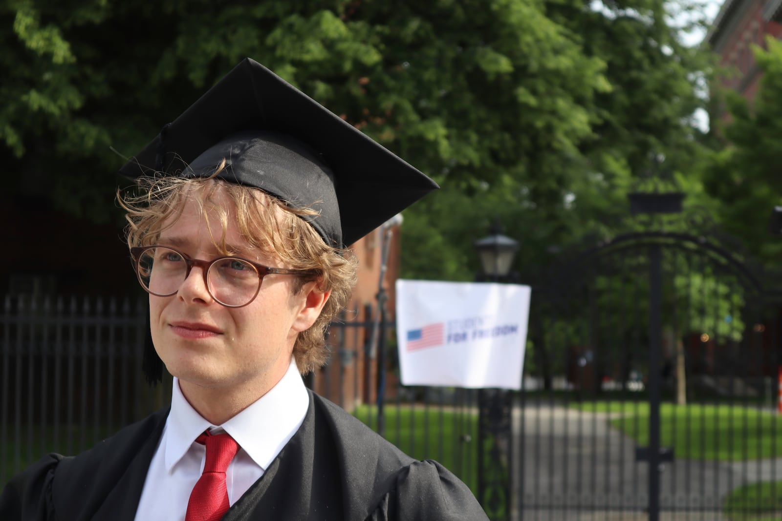 Harvard University graduating senior Leo Gerdén, an international student from Sweden, stands outside the Harvard University gates before a student protest against President Donald Trump's recent sanctions against Harvard, Tuesday May 27, 2025, in Cambridge, Mass. (AP Photo/Leah Willingham)