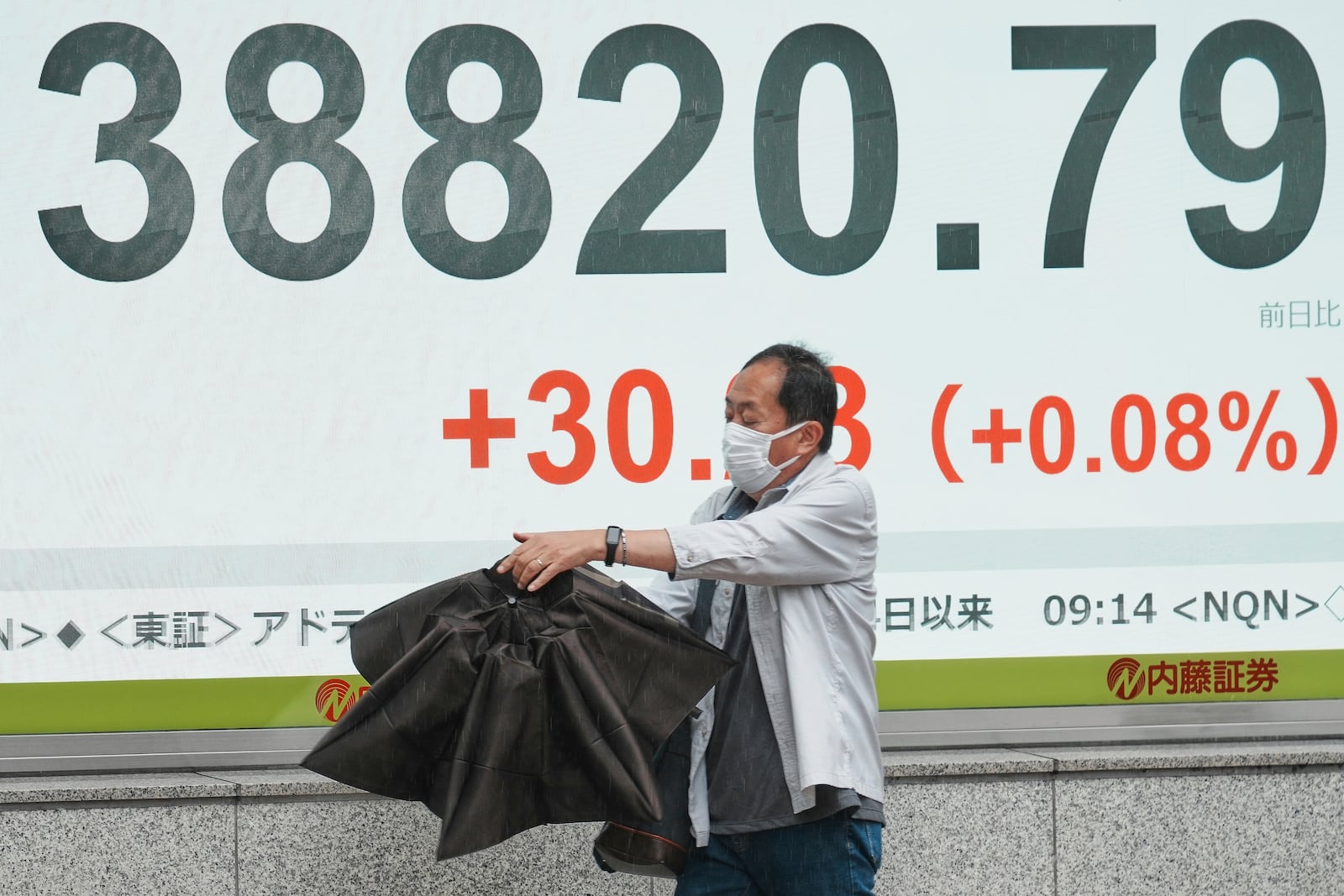 A person walks in front of an electronic stock board showing Japan's Nikkei index at a securities firm Wednesday, June 25, 2025, in Tokyo. (AP Photo/Eugene Hoshiko)