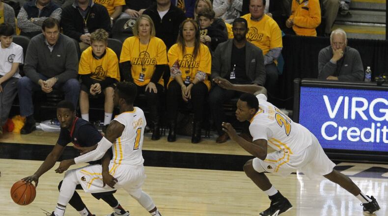 Dayton’s Scoochie Smith brings the ball up the court against Virginia Commonwealth’s JeQuan Lewis (1) and Treveon Graham, far right, on Saturday, Feb. 28, 2015, at the Siegel Center in Richmond, Va. David Jablonski/Staff
