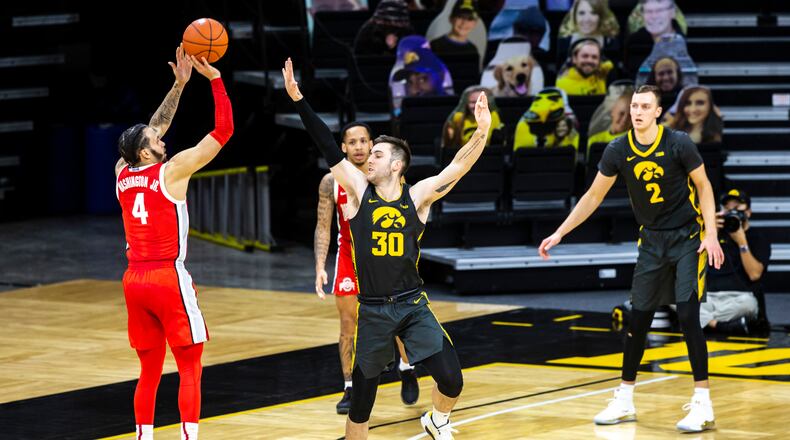 Ohio State guard Duane Washington Jr. (4) makes a three-point basket as Iowa's Connor McCaffery (30) defends in the second half during an NCAA college basketball game Thursday, Feb. 4, 2021, in Iowa City, Iowa. (Joseph Cress/Iowa City Press-Citizen via AP)