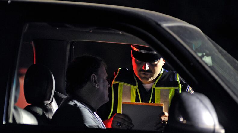 Monroe police officer Doug Leist works at an OVI checkpoint Early Saturday morning, June 11, 2011 along OH-4.