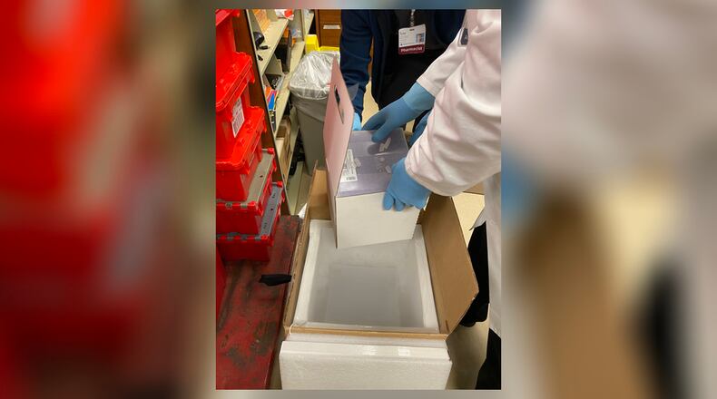 Two Mercy Health - Springfield employees handle a box of Pfizer COVID-19 vaccines. Gov. Mike DeWine announced on Thursday that those 85-plus could begin receiving the vaccine next week, Clark County Combined Health District Commissioner Charles Patterson said on Friday that the health district “does not have any vaccine for 1b, nor do we know yet how much vaccine we are going to get.” Contributed