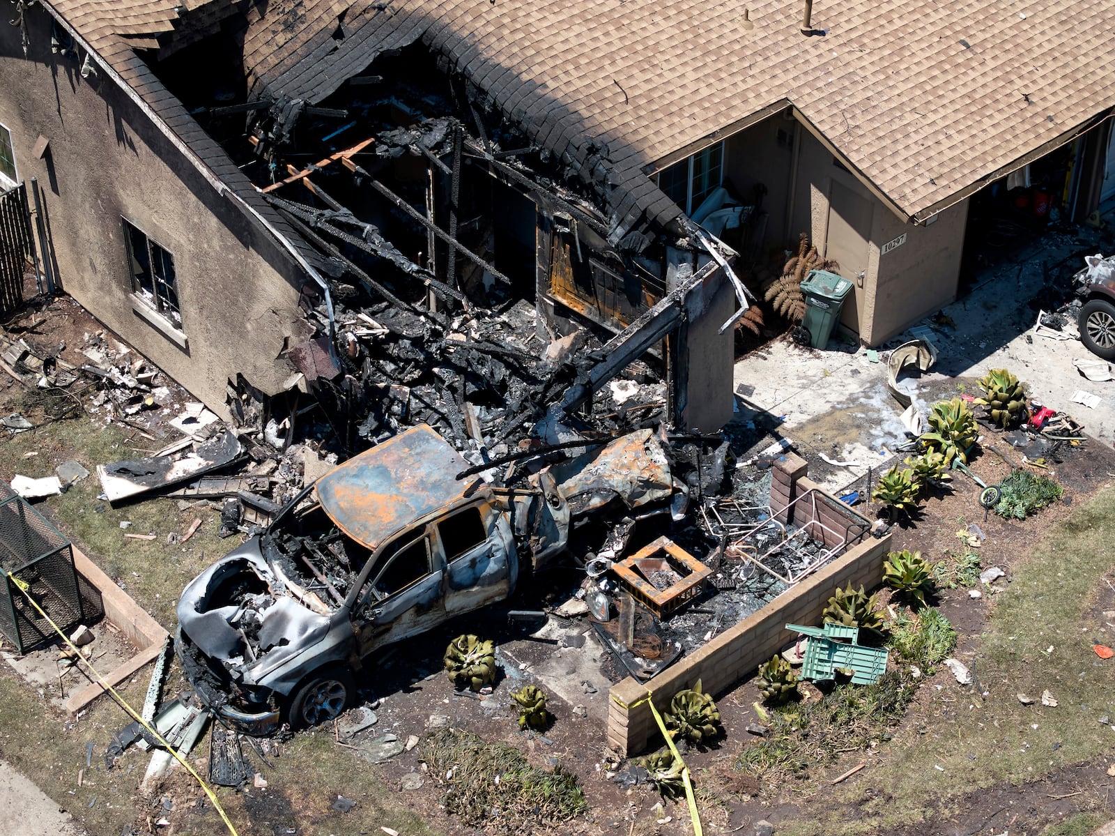 Debris covers the ground after a small plane crashed into a San Diego neighborhood, setting homes and cars on fire and forcing evacuations early Thursday, May 22, 2025. (AP Photo/William Liang)