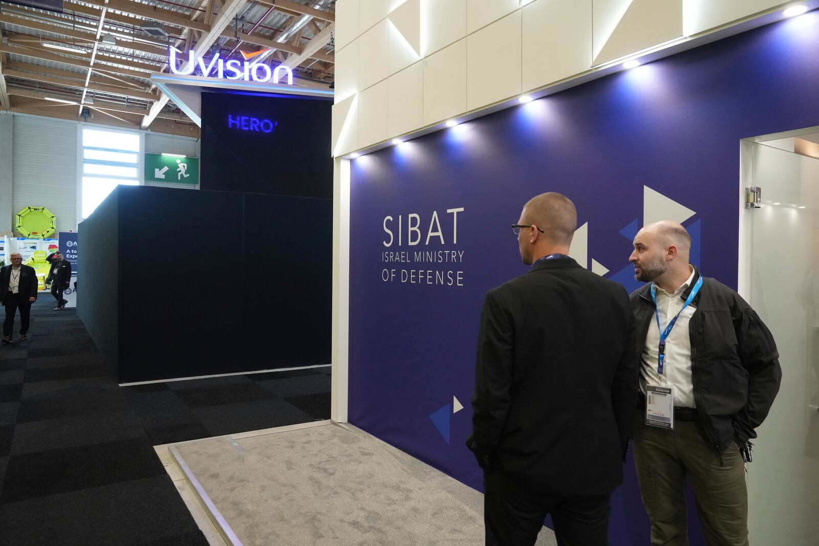 People stand by a black wall that blocks the Israeli pavilions has been erected at the Paris Air Show , Monday, June 16, 2025 in Le Bourget, north of Paris. (AP Photo/Michel Euler)