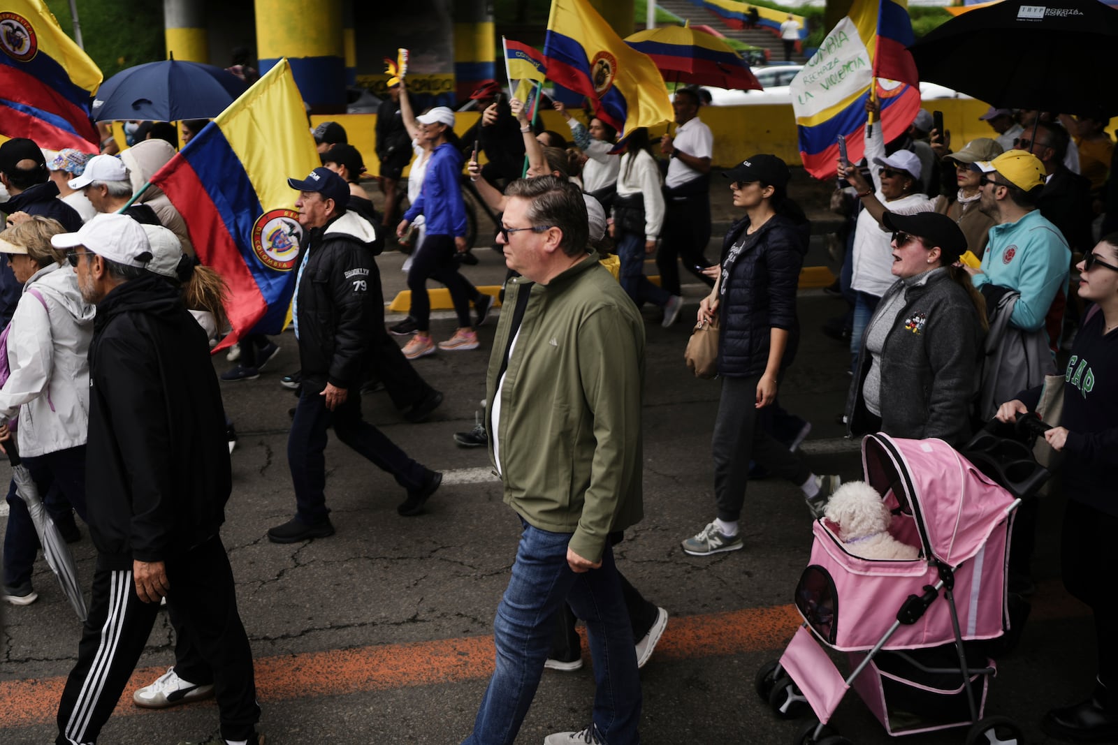 People march to the clinic where Colombian Senator Miguel Uribe Turbay is being treated after he was shot, in Bogota, Colombia, Sunday, June 8, 2025. (AP Photo/Ivan Valencia)