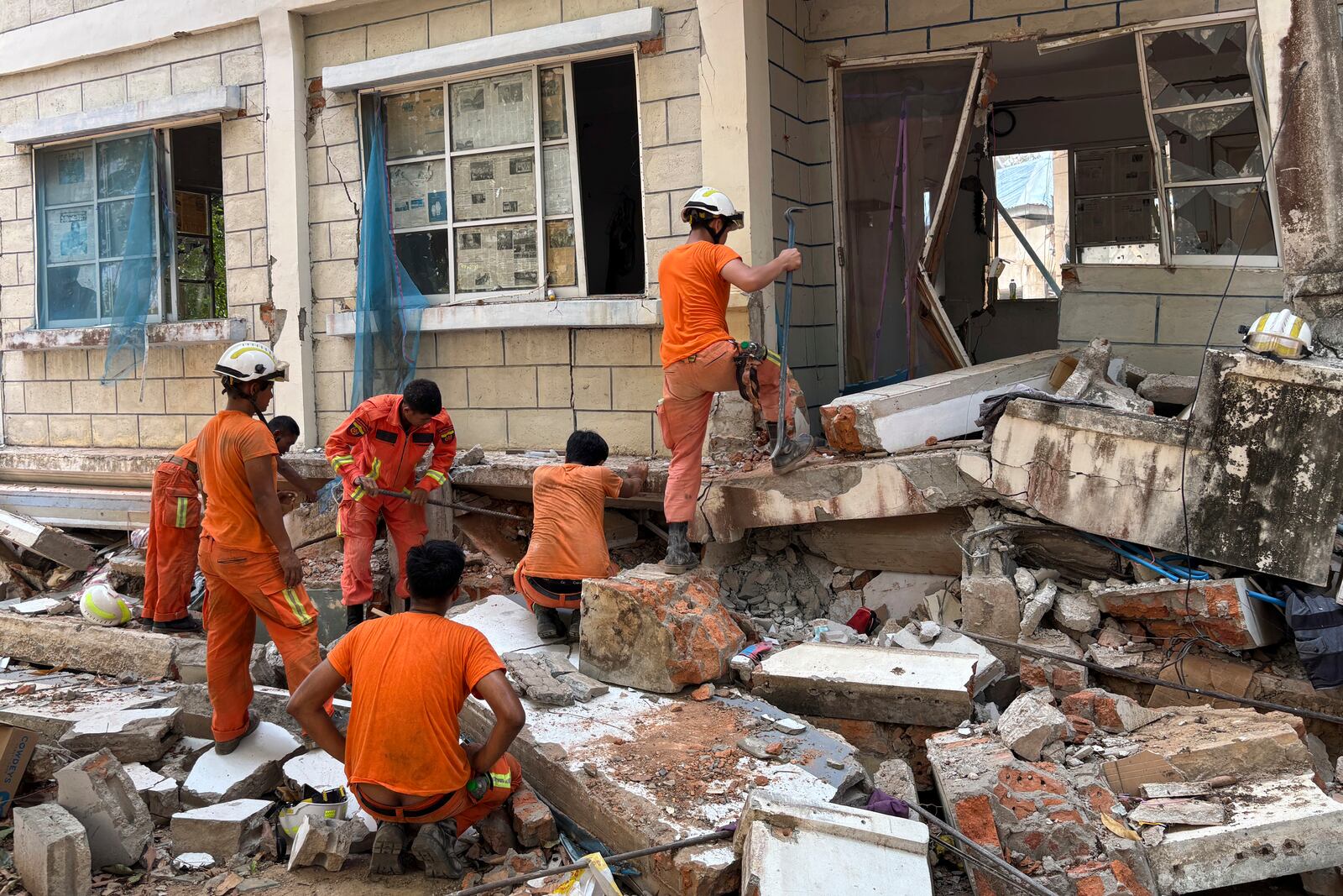 Firefighters recover the belongings of victims of the earthquake from damaged buildings that house Governments' servants in Naypyitaw, Myanmar, Monday, April 28, 2025. (AP Photo/Aung Shine Oo)