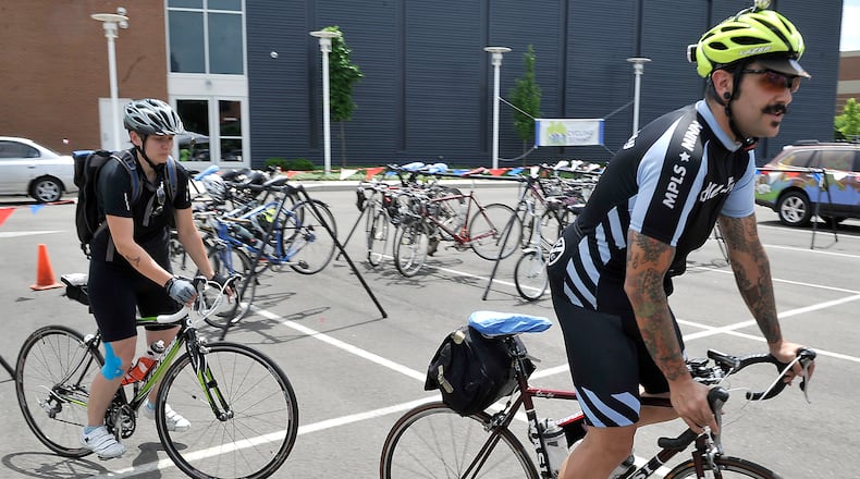 Brian Whitten, of Dayton, right, and Ulrike Fiedler, of Dayton, take off on their bikes from the Bike Parking area outside the Miami Valley Cycling Summit at the Hollenbeck-Bayley Conference Center on Friday, May 31, 2013. Whitten and Fiedler along with several dozen other cyclists from all over the Miami Valley rode their bikes to the summit in downtown Springfield. Bill Lackey/Staff