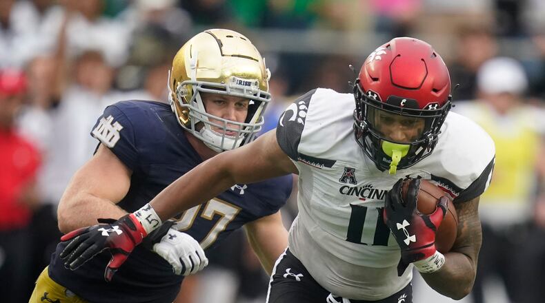 Cincinnati's Leonard Taylor (11) is chased by Notre Dame's JD Bertrand (27) during the second half of an NCAA college football game, Saturday, Oct. 2, 2021, in South Bend, Ind. Cincinnati won 24-13. (AP Photo/Darron Cummings)