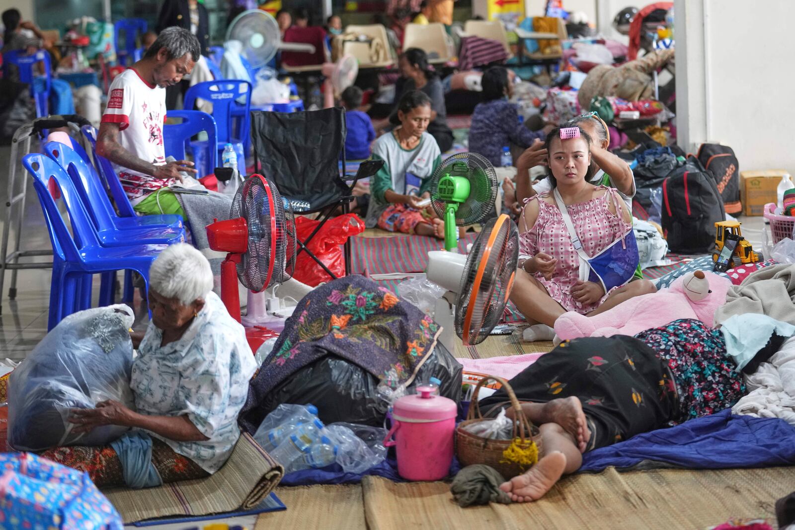 Thai residents who fled homes following clashes between Thai and Cambodian soldiers rest at an evacuation center in Surin province, Thailand, Sunday, July 27, 2025. (AP Photo/Sakchai Lalit)