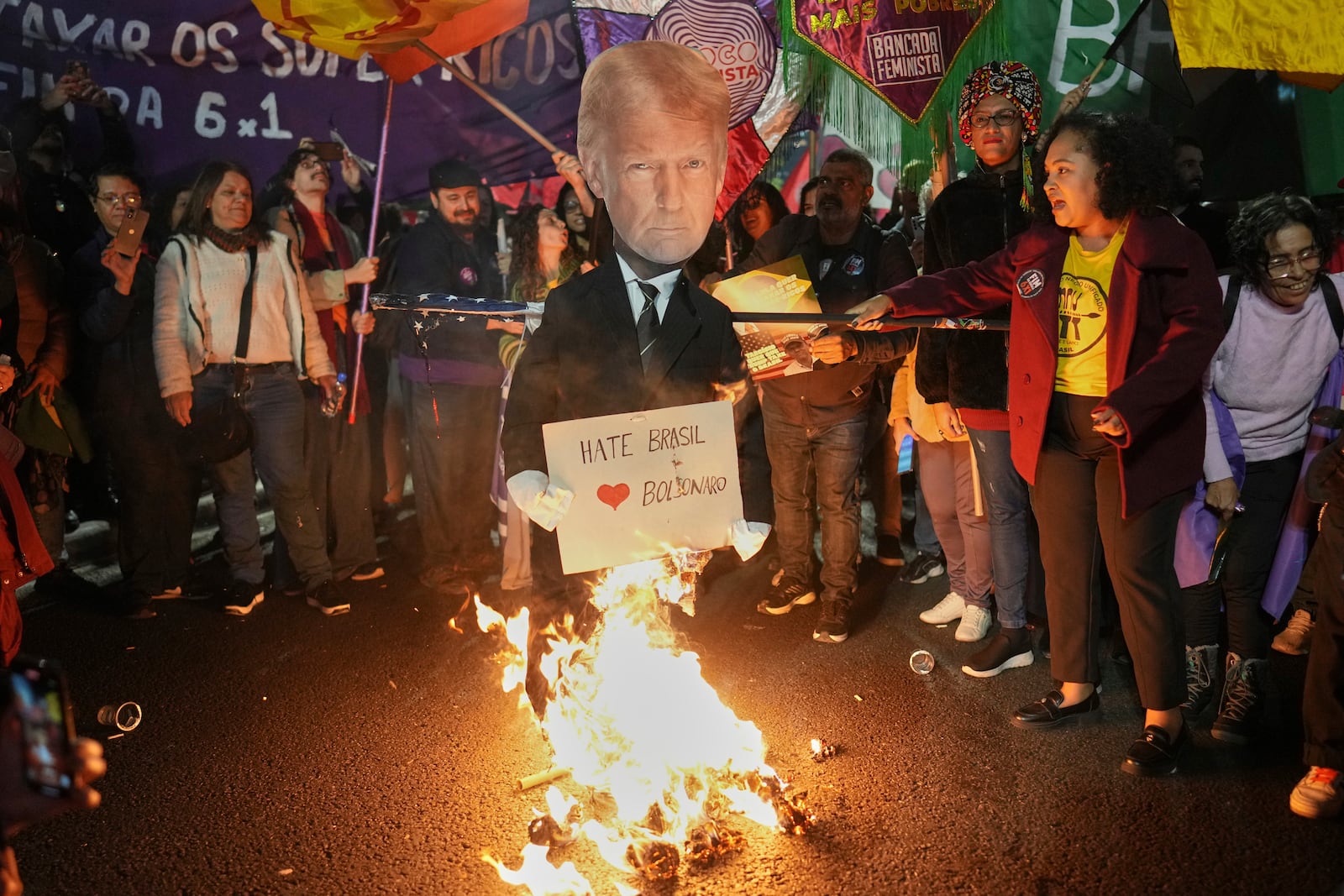 Supporters of Brazilian President Luiz Inacio Lula da Silva set fire to an effigy of U.S. President Donald Trump during a protest against Trump's announcement of 50% tariffs on Brazil, in São Paulo, Thursday, July 10, 2025. (AP Photo/Andre Penner)