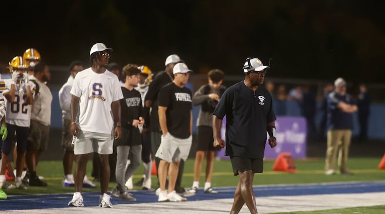 Springfield's Maurice Douglass coaches with his son Moses (left) looking on during a game against Springboro on Friday, Sept. 26, 2025, at CareFlight Field in Springboro. DAVID JABLONSKI / STAFF