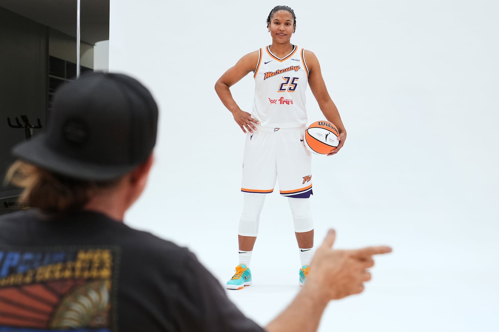 Phoenix Mercury forward Alyssa Thomas (25) takes direction from team photographer Barry Gossage during Mercury Media Day at the team's WNBA basketball training facility, Wednesday, April 30, 2025, in Phoenix. (AP Photo/Ross D. Franklin)