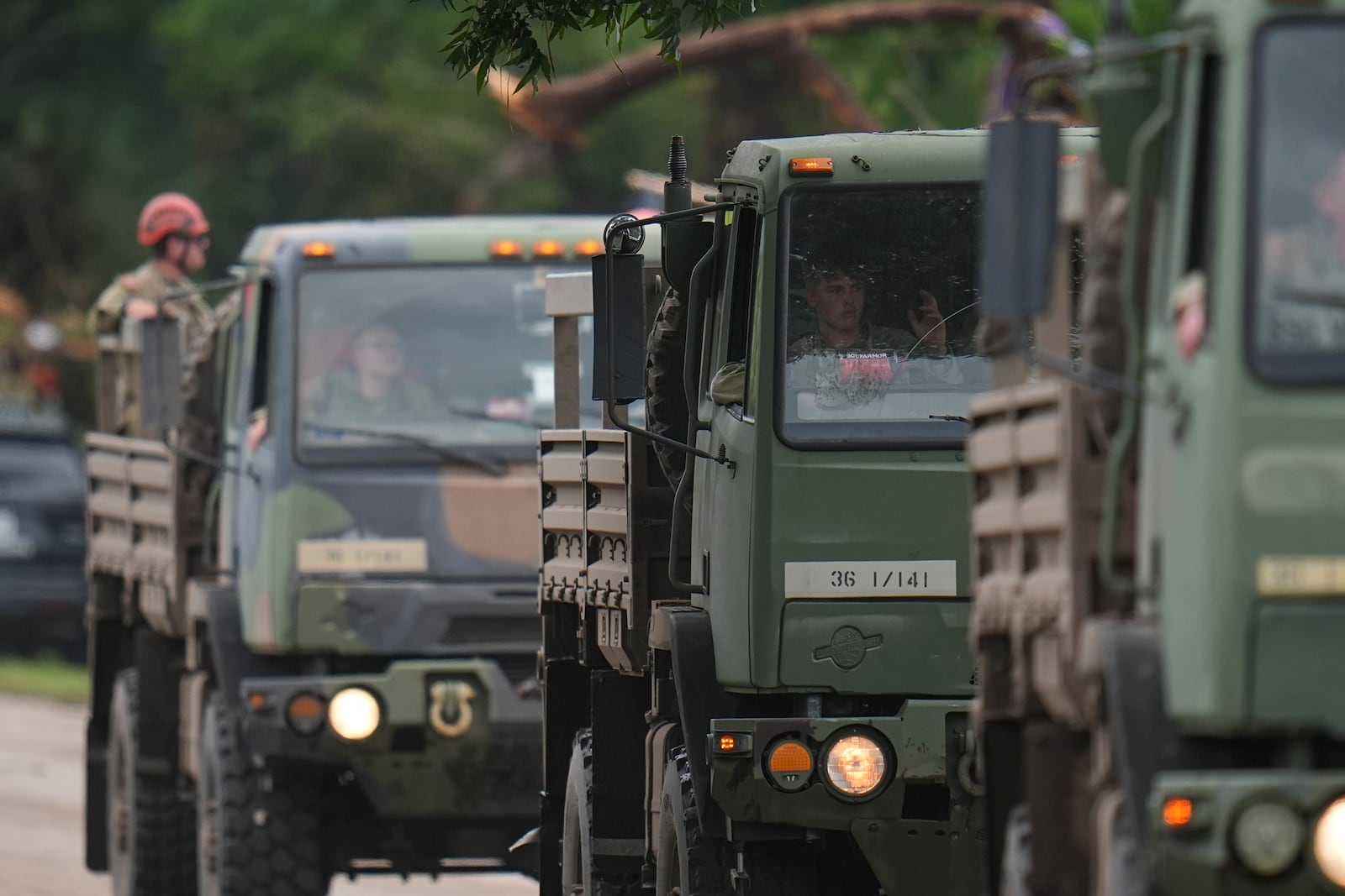A military convoy drives on a road along the Guadalupe River after a flash flood swept through the area Saturday, July 5, 2025, in Hunt, Texas. (AP Photo/Julio Cortez)