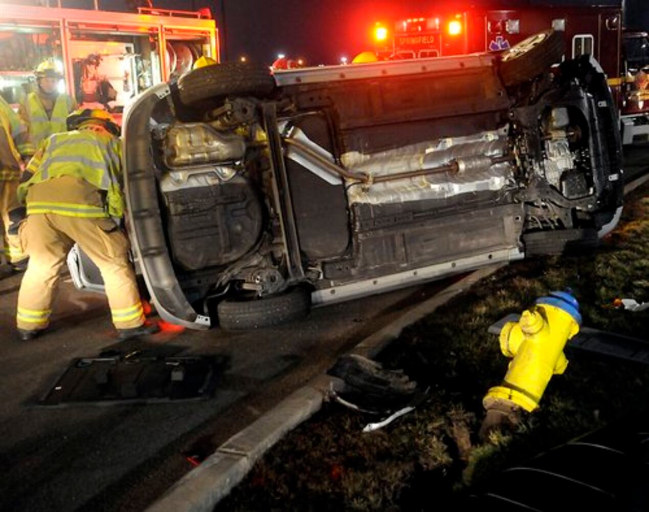 Car hits fire hydrant, turns on side