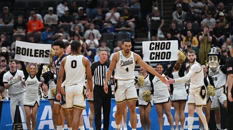 Purdue's Trey Kaufman-Renn (4) celebrates with teammate Braden Smith, right, and C.J. Cox (0) during the second half in the first round of the NCAA college basketball tournament against Queens University, Friday, March 20, 2026, in St. Louis. (AP Photo/Ali Overstreet)