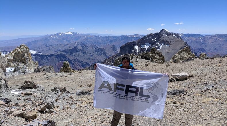 Air Force Research Laboratory researcher Kevin D. Schmidt unfurls an AFRL flag on Mount Aconcagua in South America. CONTRIBUTED
