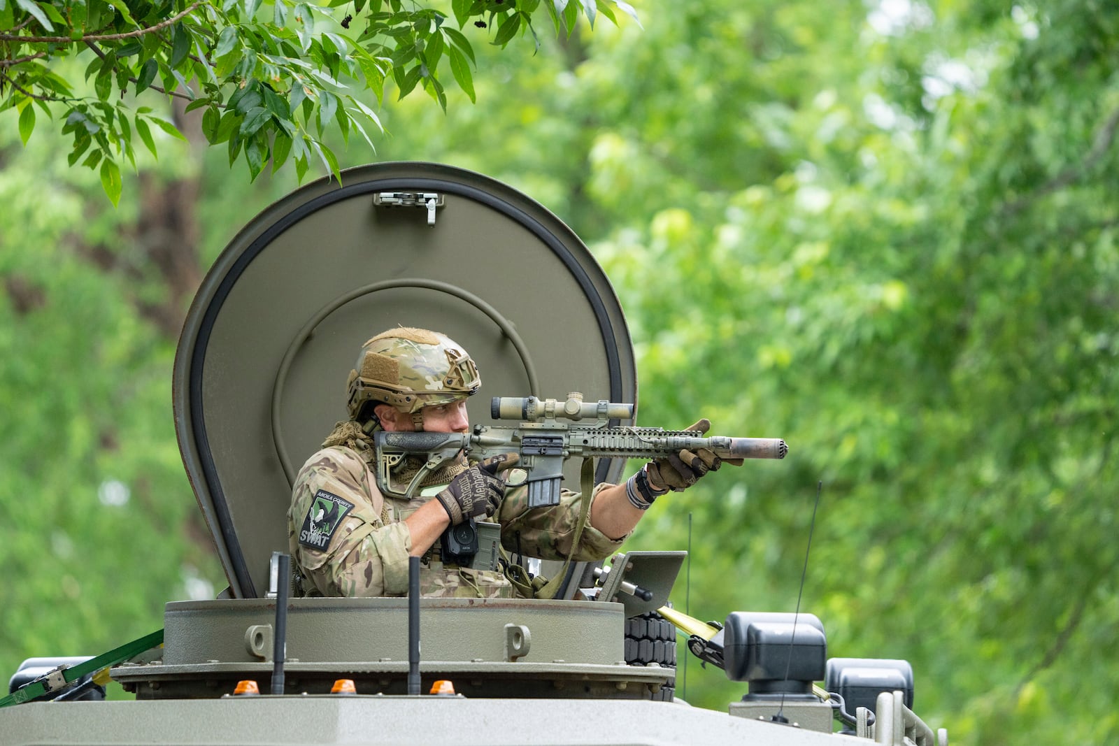 An amed FBI agent in an armored vehicle takes part in the search for an active shooter, sweeping a neighborhood adjacent to the home of Minnesota DFL State Representative Melissa Hortman, in Brooklyn Park, Minn., Saturday, June 14, 2025. (Alex Kormann/Star Tribune via AP)