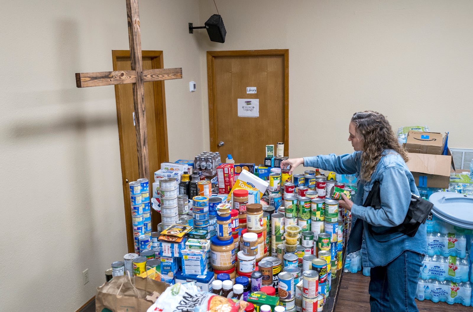 Parishioner Lisa Reitz gets cans of food and other donations ready for distribution at the Hunt Baptist Church following extreme flooding along the Guadalupe River on Sunday, July 6, 2025, in Hunt, Texas. (AP Photo/Rodolfo Gonzalez)