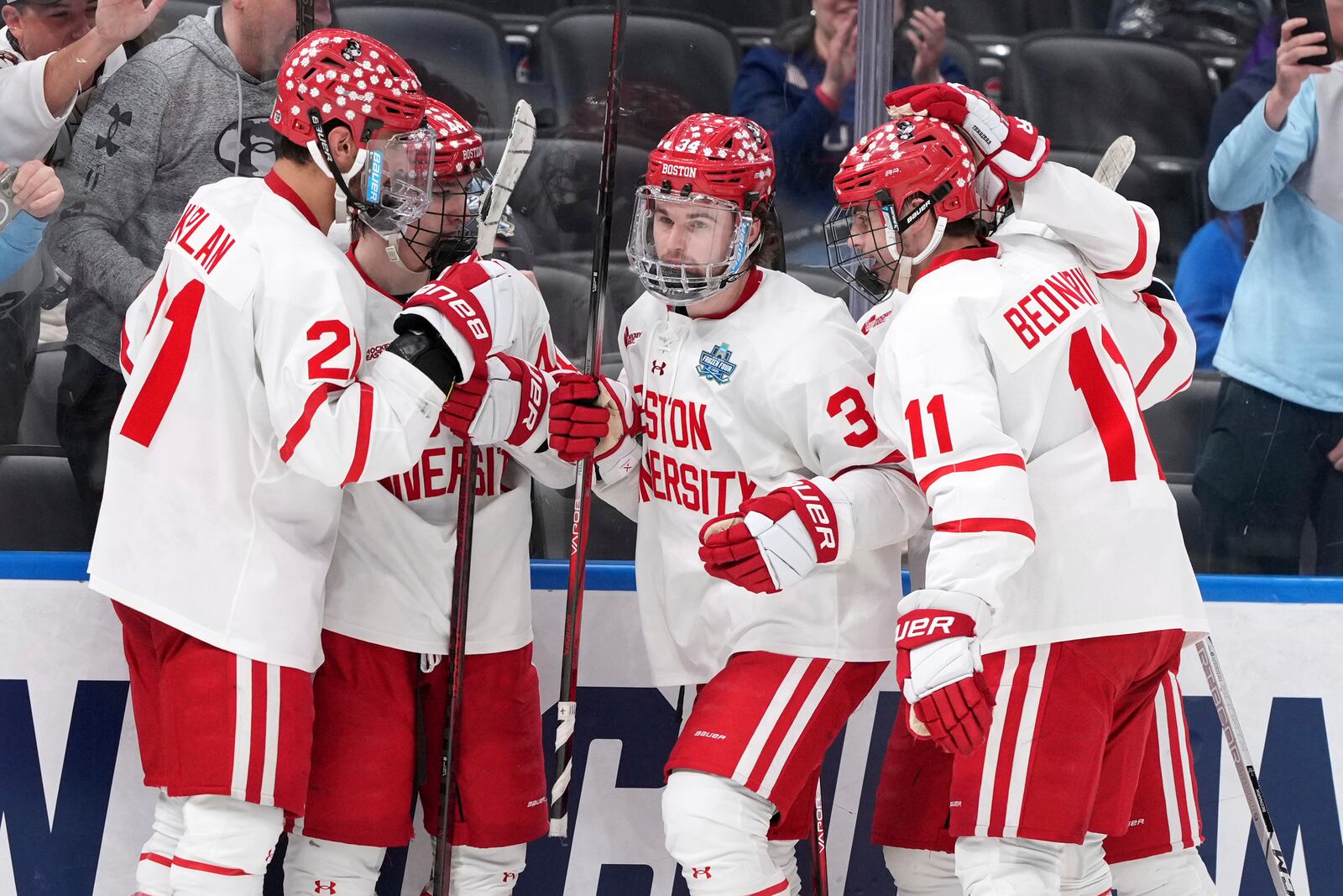 Boston University's Cole Eiserman (34) is congratulated by teammates after scoring during the second period in a semifinal game in the NCAA Frozen Four men's college hockey tournament against Penn State, Thursday, April 10, 2025, in St. Louis (AP Photo/Jeff Roberson)