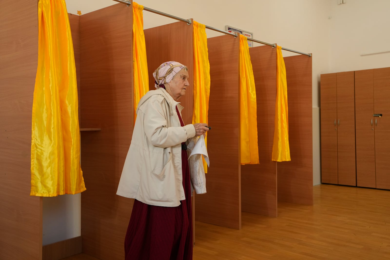 A woman exits after casting her vote in the first round of the presidential election redo in Bucharest, Romania, Sunday, May 4, 2025. (AP Photo/Vadim Ghirda)