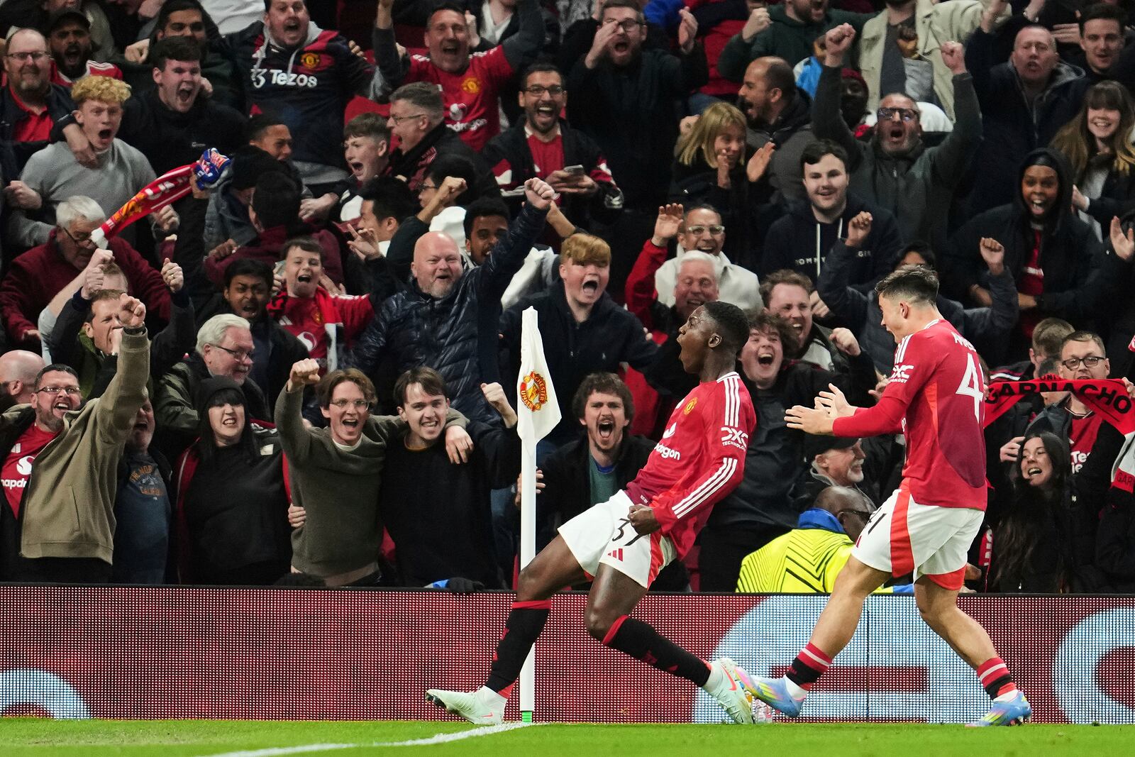 Manchester United's Kobbie Mainoo celebrates after scoring his side's fourth goal during the Europa League quarter final second leg soccer match between Manchester United and Olympique Lyon in Manchester, Britain, Thursday, April 17, 2025. (AP Photo/Jon Super)