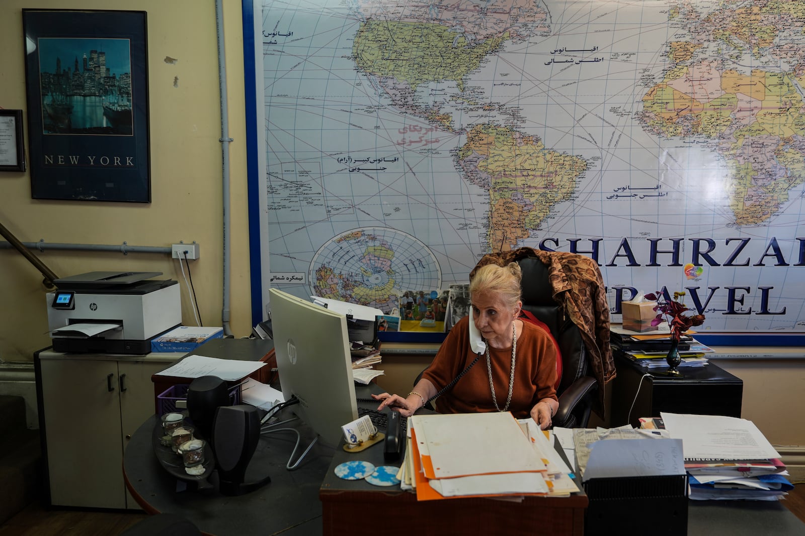Shahrzad Tahouri works at her travel agency in the "Tehrangeles" neighborhood of Los Angeles Tuesday, June 24, 2025. (AP Photo/Jae C. Hong)