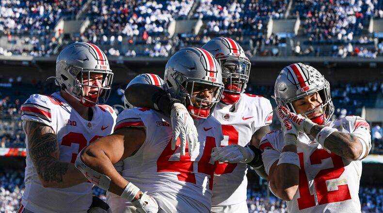 FILE0 Ohio State defensive end J.T. Tuimoloau (44) celebrates with his teammates Jack Sawyer (33), Zach Harrison (9) and Lathan Ransom (12) after returning an interception for a touchdown during the fourth quarter of an NCAA college football game against Penn State, on Oct. 29, 2022, in State College, Pa. Even though they're playing for a shot at the national championship in the Peach Bowl's College Football Playoff semifinal against No. 1 Georgia on Saturday, No. 4 Ohio State players haven't moved past their 45-23 loss to rival Michigan on Nov. 26. (AP Photo/Barry Reeger, File)