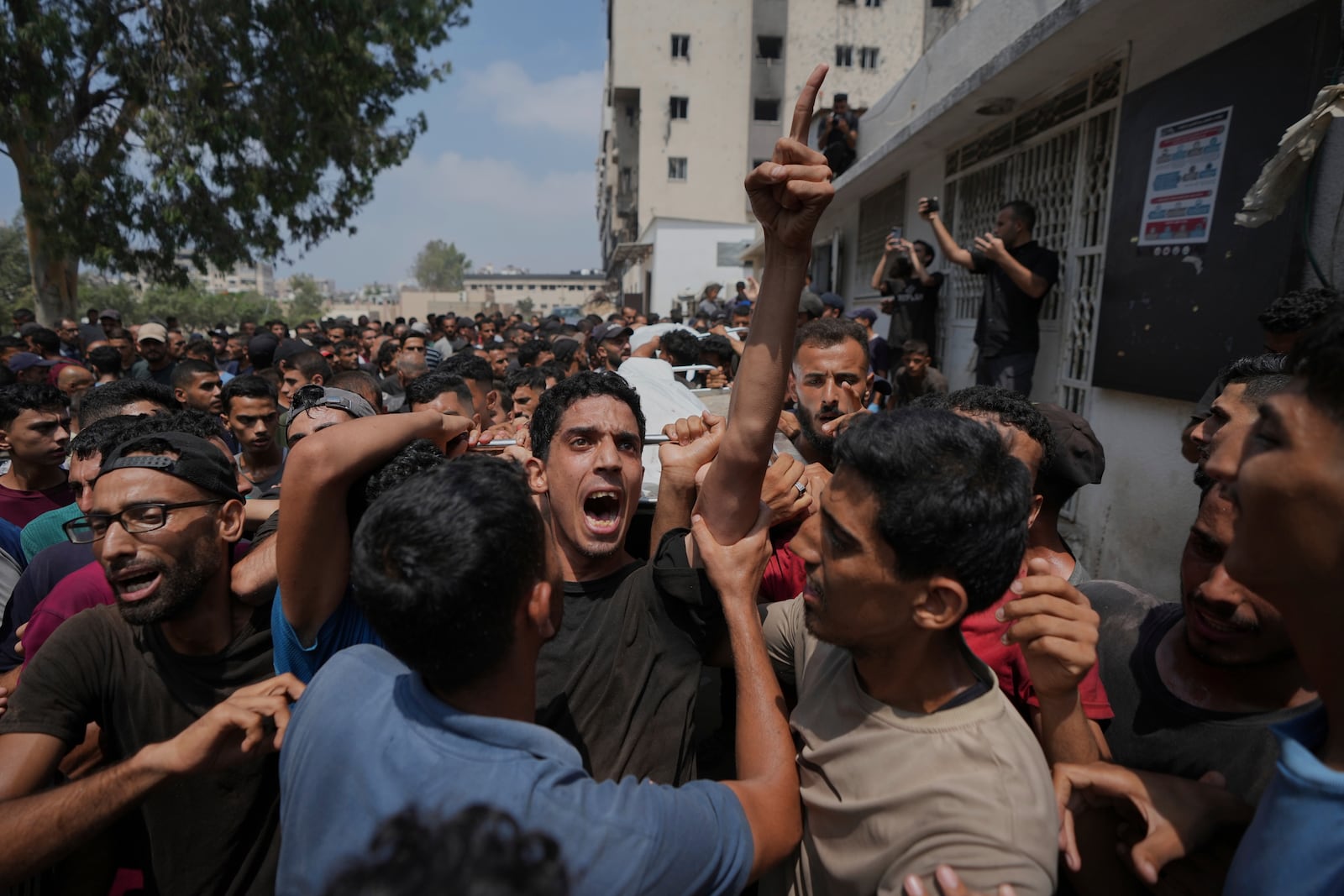 Palestinians carry the bodies of people who were killed in an Israeli airstrike on a school in Gaza that have been used as a shelter, during their funeral near the Al Shifa Hospital in Gaza City, Friday, July 25, 2025. (AP Photo/Abdel Kareem Hana)