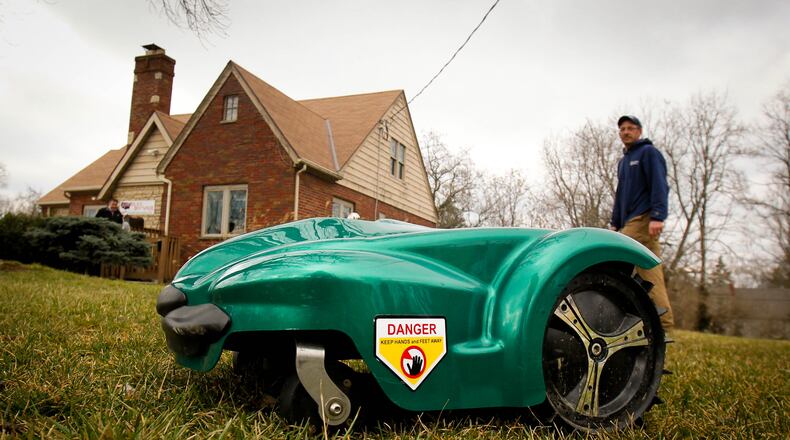 LawnBott of Dayton Manager Dave Novak watches the new Robotic lawn mower navigate his lawn unassisted.