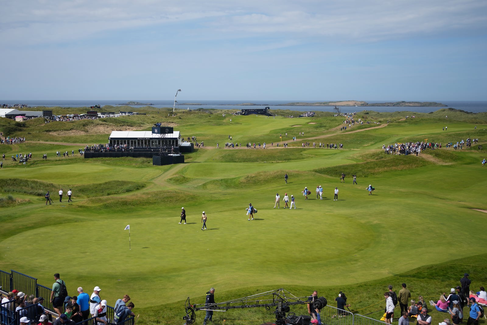 A group of players including Rickie Fowler of the United States walk onto the 14th green ring a practice round for the British Open golf championship at the Royal Portrush Golf Club, Northern Ireland, Wednesday, July 16, 2025. (AP Photo/Jon Super)
