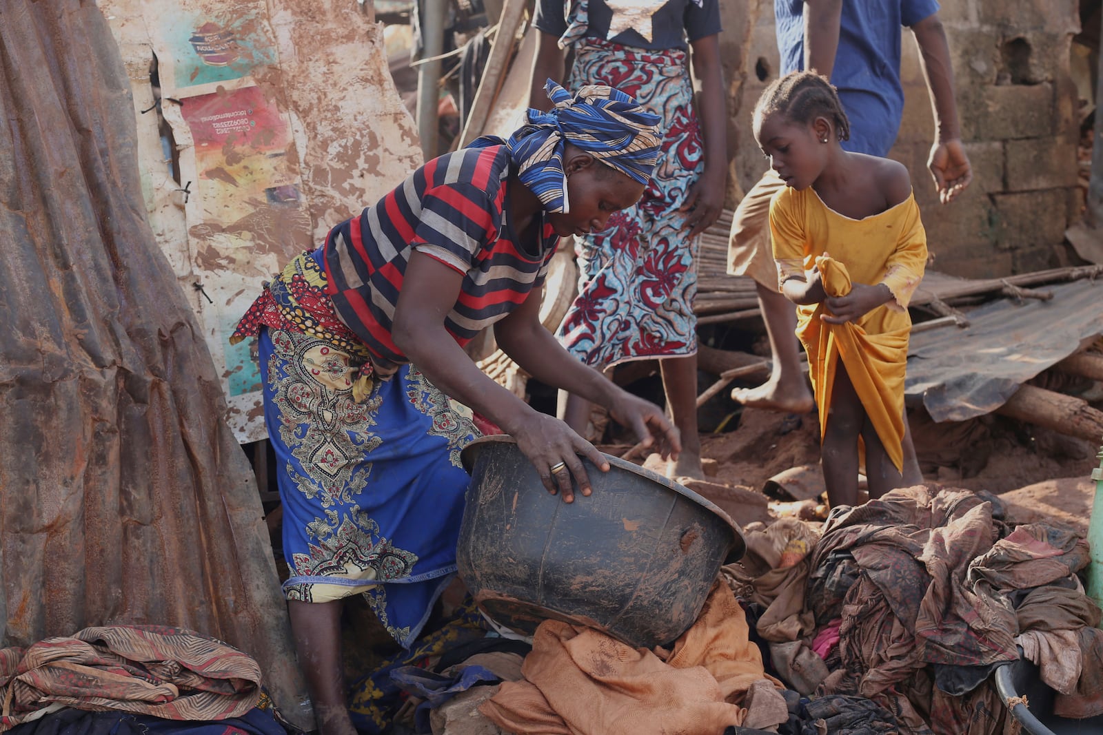 People salvage their belongings in a flooded area after heavy rainfall in the market town of Mokwa, north-central Nigeria, Saturday May 31, 2025. (AP Photo/Usman Salihu Mokwa)