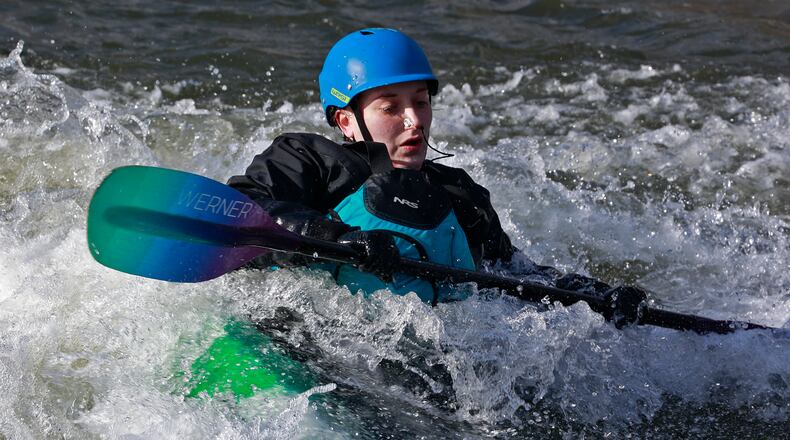 Trisha Garrettson surfs the rapids in a kayak Tuesday, Jan. 17, 2023 as she takes advantage of the sunshine at the white water feature in Snyder Park. BILL LACKEY/STAFF