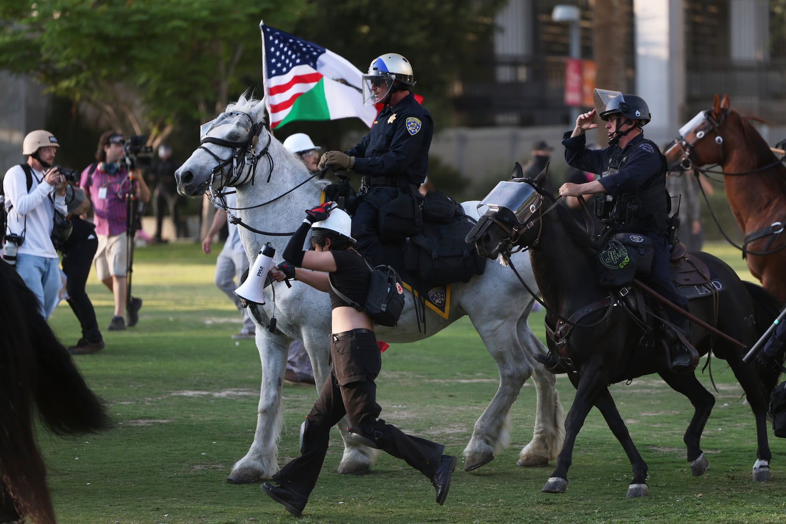Los Angeles Metro police on horseback disperse protesters on Wednesday, June 11, 2025, in Los Angeles. (AP Photo/Ethan Swope)