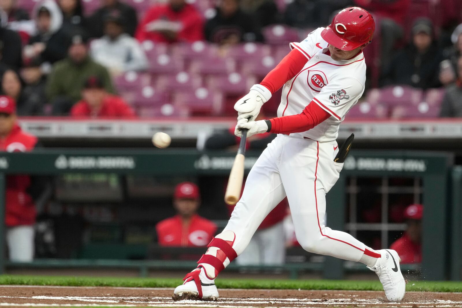 Cincinnati Reds' TJ Friedl hits a single in the first inning of a baseball game against the Texas Rangers, Monday, March 31, 2025, in Cincinnati. (AP Photo/Kareem Elgazzar)