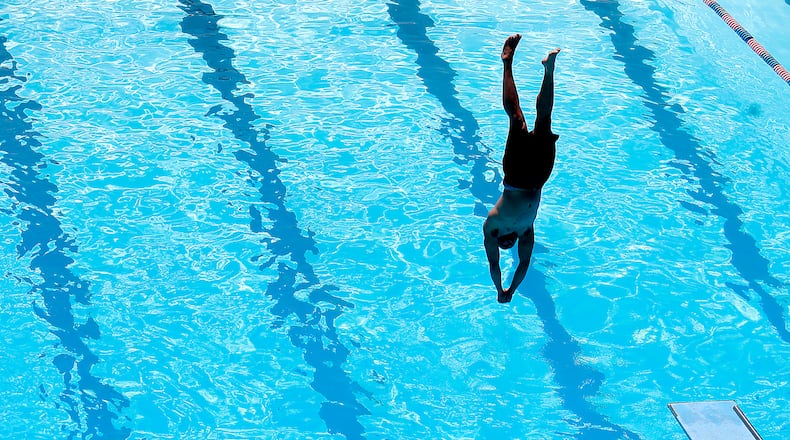 A diver hangs over the water just before breaking the surface Friday, June 2, 2023 at Splash Zone Aquatic Center in Springfield. BILL LACKEY/STAFF