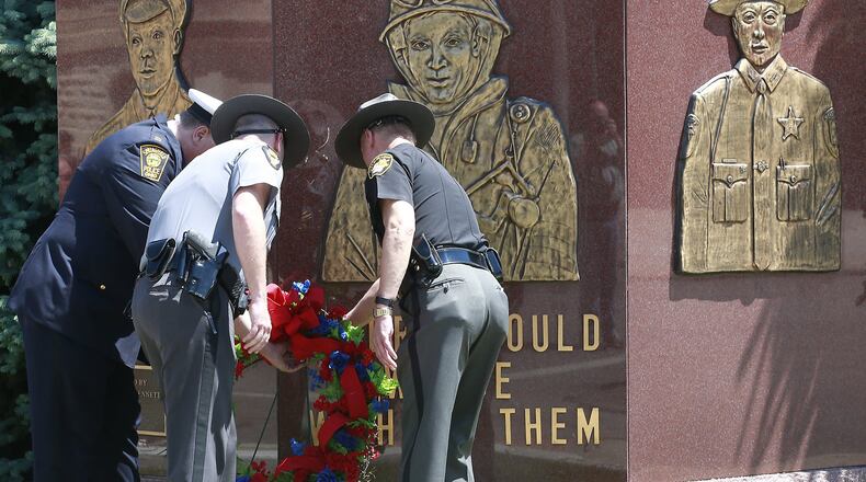 Representatives from the Springfield Police Division, Ohio Highway Patrol, and Clark County Sheriff’s office place a memorial wreath at the safety officers memorial years ago during the annual Law Day ceremony remembering officers and firefighters who have died in the line of duty. File photo by Bill Lackey