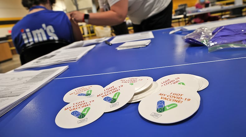 A pile of "I Got My COVID-19 Vaccine!" stickers waits for students and adults to get their vaccine shot at a vaccine clinic at Shawnee High School.