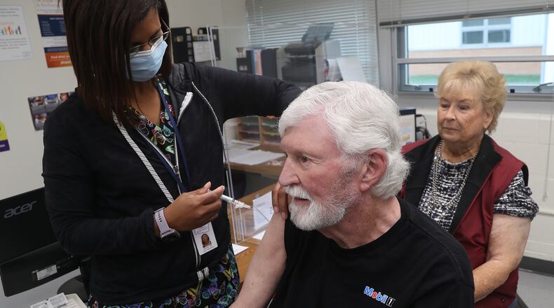 Clark County Combined Health District nurse Salimah Berrien gives Jack Sayers his flu vaccine as his wife, Nancy, waits her turn Wednesday, Oct. 19, 2022. BILL LACKEY/STAFF