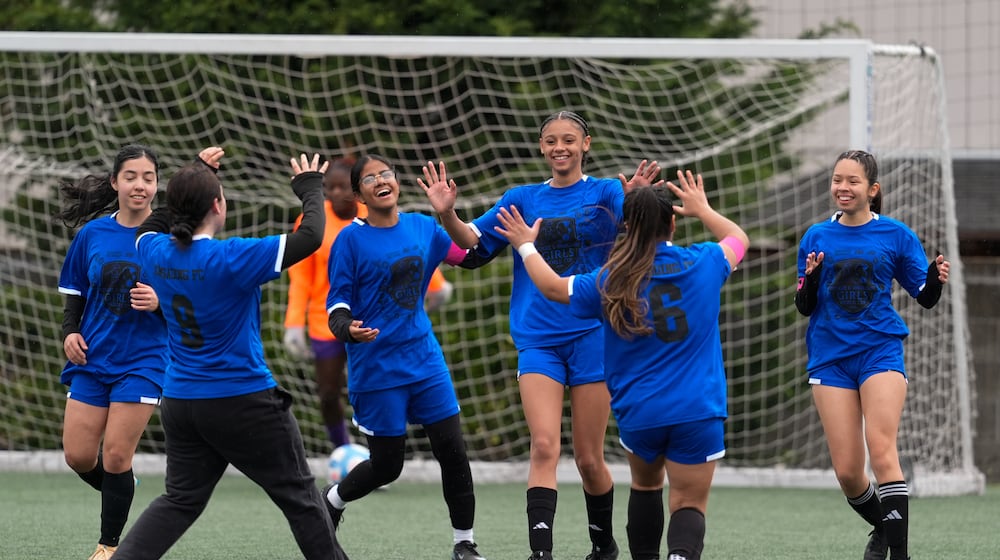 Aubrey Decraig, third from right, celebrates with teammates after scoring a goal during a soccer tournament for immigrant and refugee girls on Sunday, March 29, 2026, in Portland, Ore. (AP Photo/Jenny Kane)